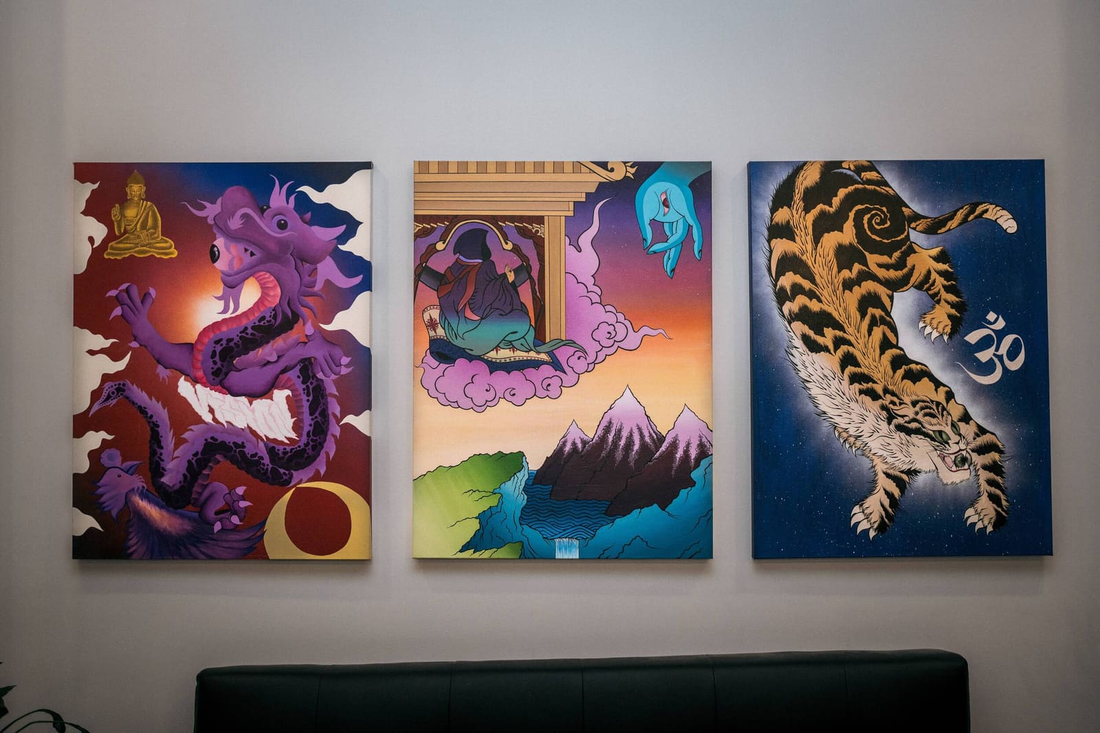 Three paintings in the studio: a purple dragon, a temple in the mountains and a tiger