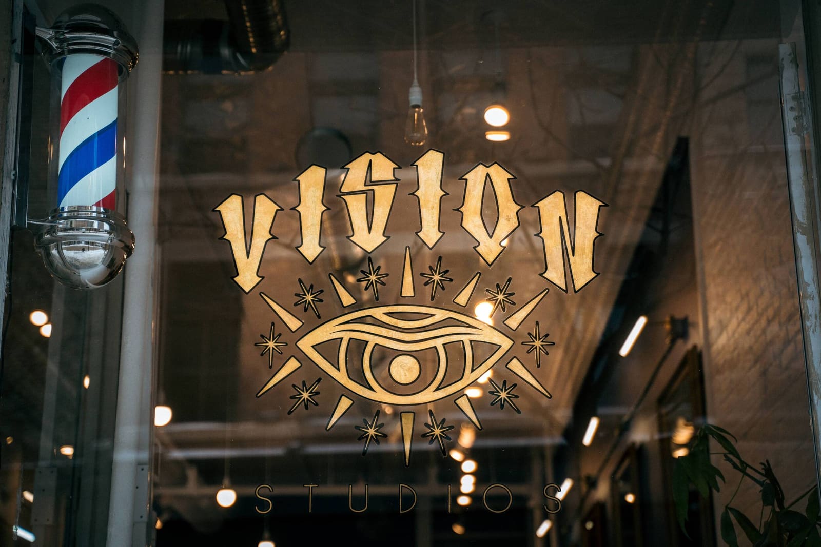 The gold Vision eye on the front window beside a barber pole